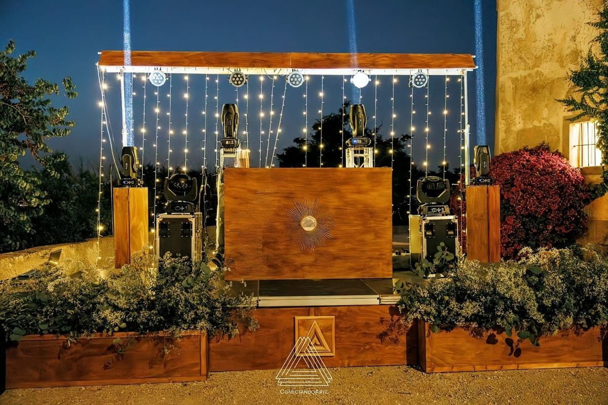 Cabina de DJ de roble con iluminación en cascada montada en una boda