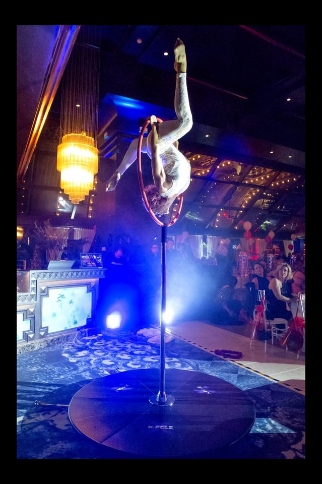 Acrobacia aérea en aro sobre una pista iluminada de un hotel